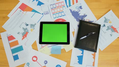 hombre usando una tableta con pantalla verde en el escritorio de la oficina, espacio de trabajo, búsqueda de información