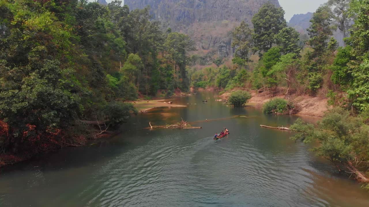 Bambini giocano nel fiume della grotta di Kong Lor con le canoe. Laos, Khammouane