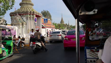 traffic and pedestrians near a traditional temple