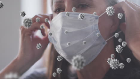 animation of virus cells over senior caucasian woman with face mask