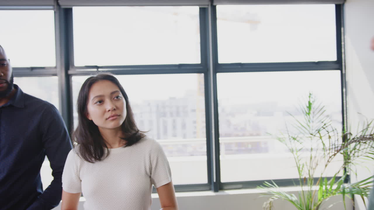 여성 매니저와 크리에이티브 동료들이 비공식 사무실 회의에서 대화하고 있습니다.