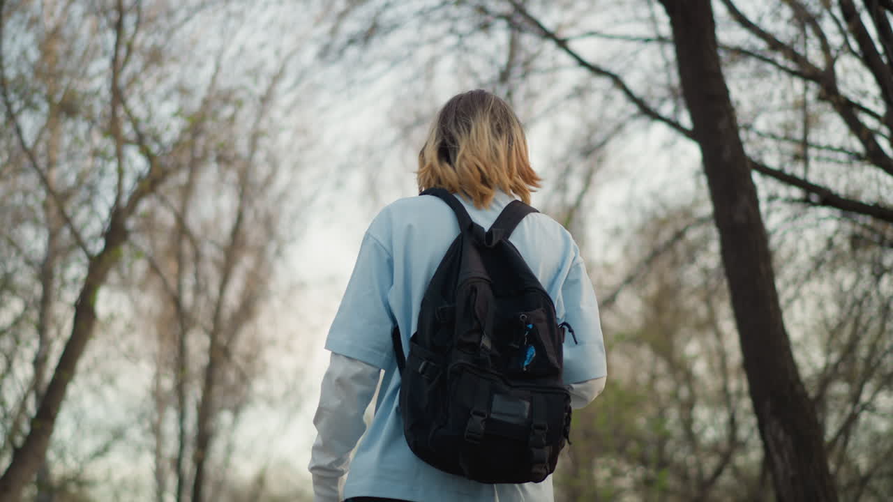 человек изучает замерзшие лесные пейзажи; уединенный путник путешествует по ледяной местности; одинокий искатель приключений осторожно передвигается по покрытому инеем лесу в тихий зимний день