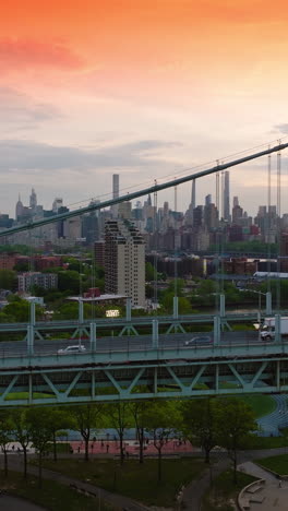 automobiles riding quickly along the large bridge. beautiful new york architecture at backdrop. vertical video