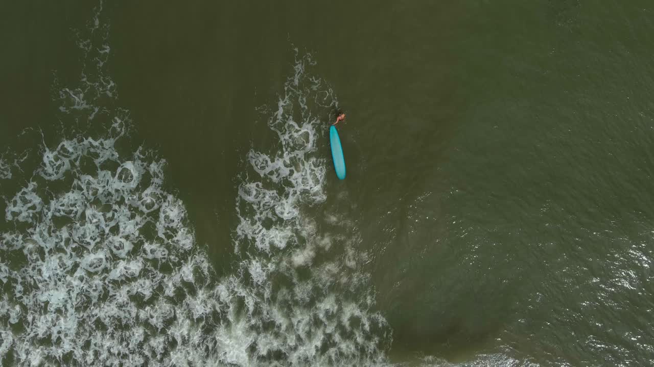 vista de pájaro de una surfista en el golfo de méxico frente a la costa del lago jackson en texas