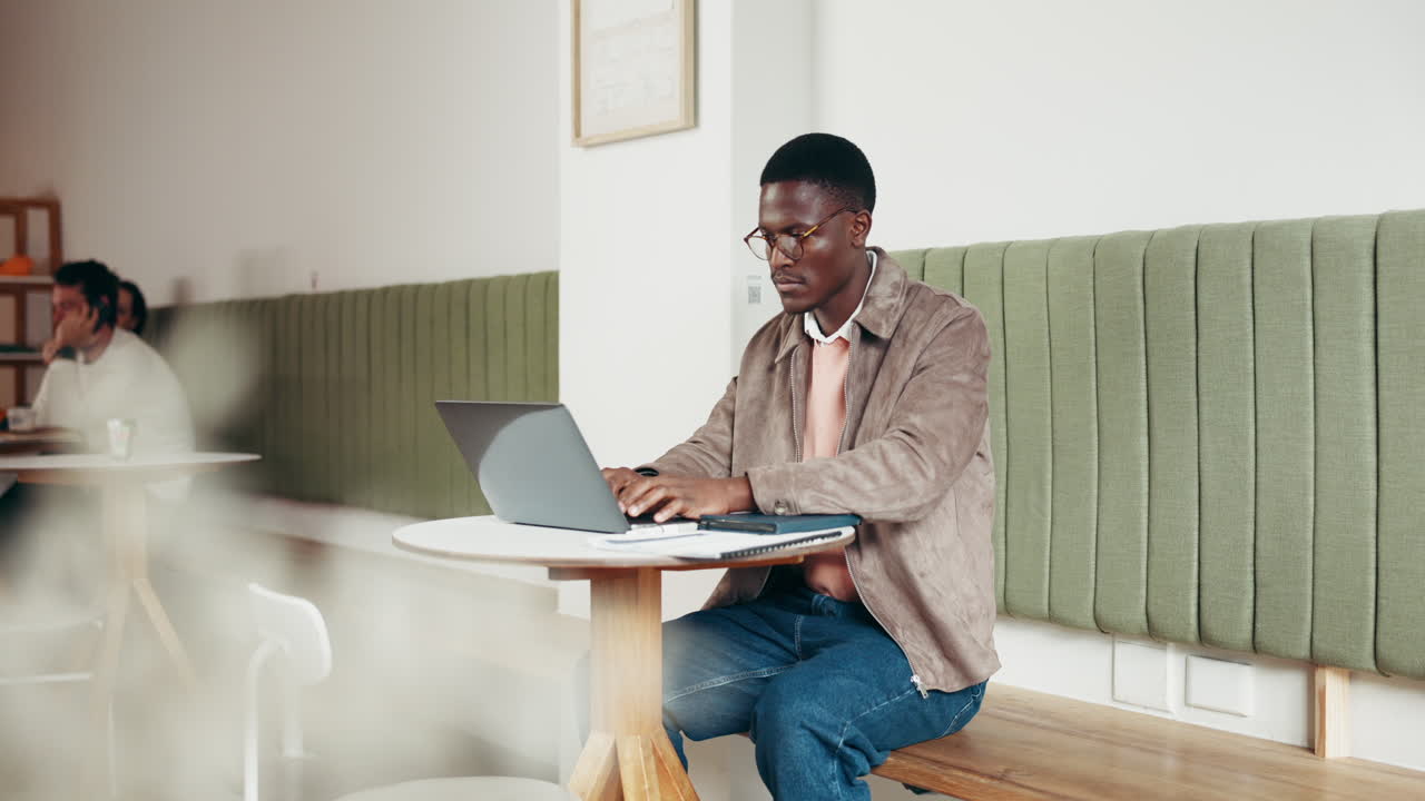 Man working on laptop in cafe