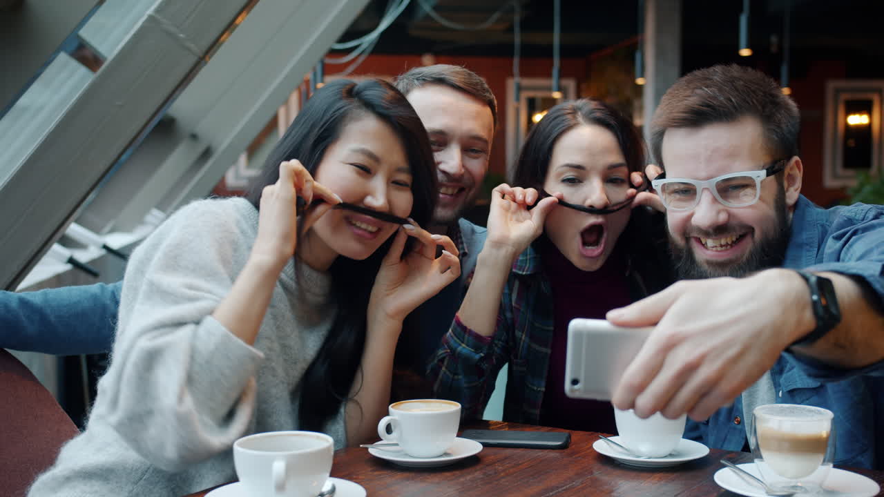 친구들이 커피에서 셀피를 찍고 있습니다.