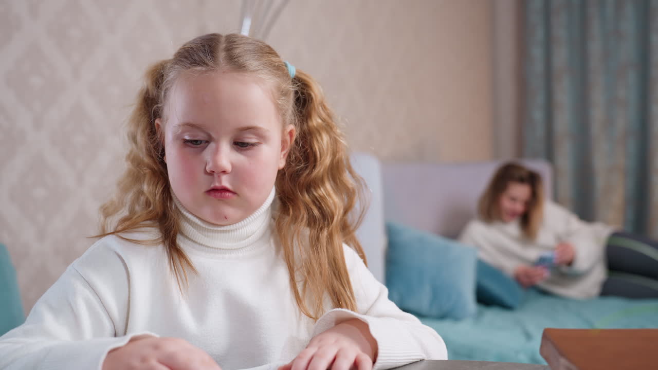 학생이 테이블에 앉아 손톱을 물어뜯고 있고, 엄마는 침대에서 스마트폰을 하며 편안하게 쉬고 있는 모습. 아늑한 집 환경은 학업 스트레스, 어린 시절 습관, 가족 라이프스타일, 집중력 저하를 상징해요.
