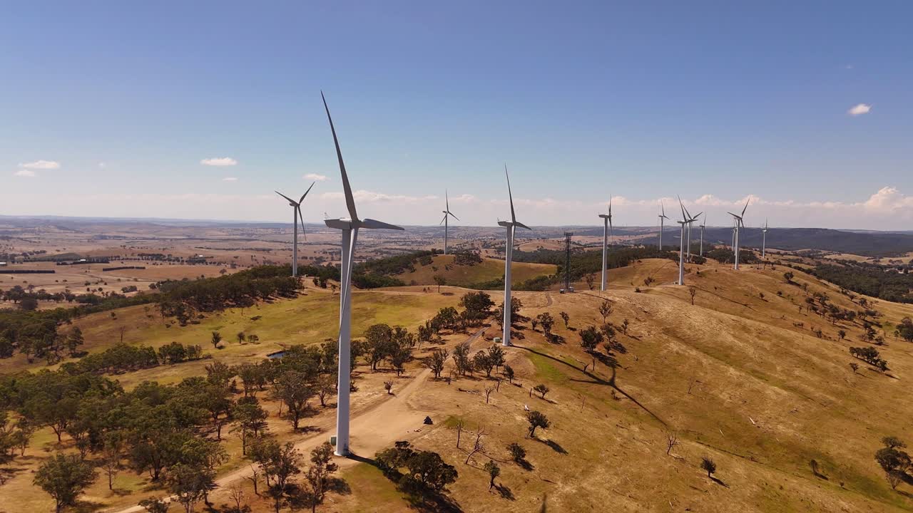 Ampla visão aérea de várias turbinas eólicas espalhadas por campos abertos, gerando energia renovável, desenvolvimento de recursos de Cullerin