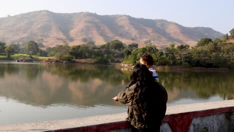 isolated young mother and son enjoying mountain landscape at morning with blurred background