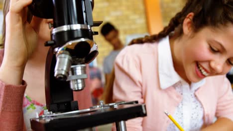 estudiantes atentos mirando a través del microscopio en el laboratorio
