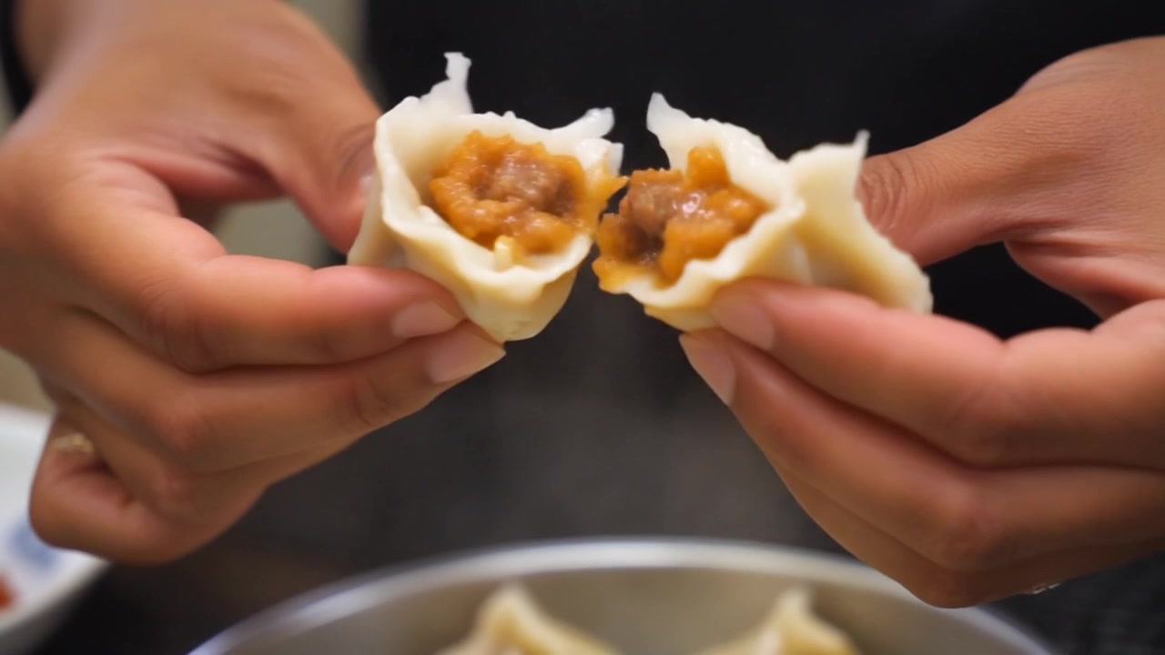 Person Breaking Open a Steaming Hot Dumpling to Reveal Filling