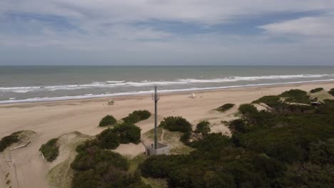 ronddraaiende luchtfoto van radioantenne op het strand