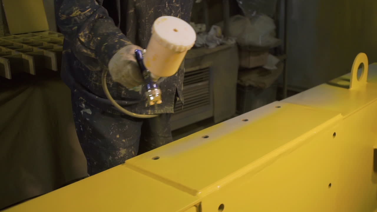 trabajador industrial pintura por pulverización estructura metálica amarilla