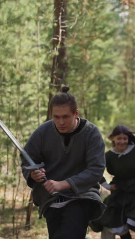 knight in chain mail and his students run to battle, weapons in hands, historical reconstruction