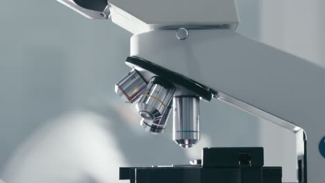 scientists rotate microscope lenses to adjust the object to be observed