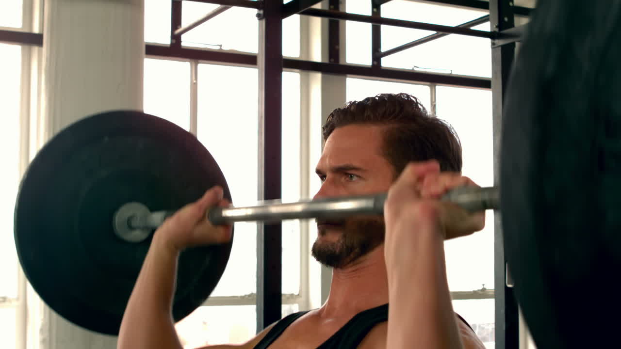 무거운 바벨을 들어 올리는 건강한 남자