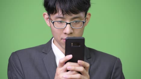 전화를 사용하는 젊은 아시아 사업가