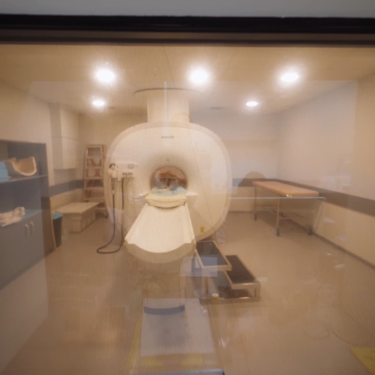 Quick movement along the laboratory for MRI analysis in modern clinics. Medical staff working in the room near the magnetic resonance machine. Women sit at computers looking through the scans