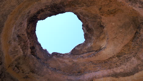 looking up at the opening of benagil sea cave