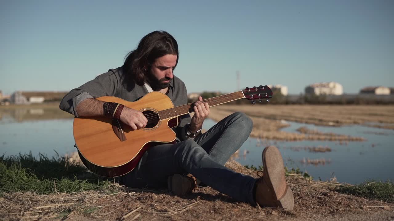 hombre tocando la guitarra acústica al aire libre