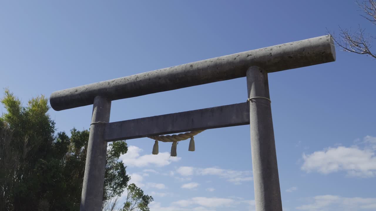 Bellissimo slider cinematografico sopra il portale Torii in pietra con cielo blu sullo sfondo in un santuario giapponese