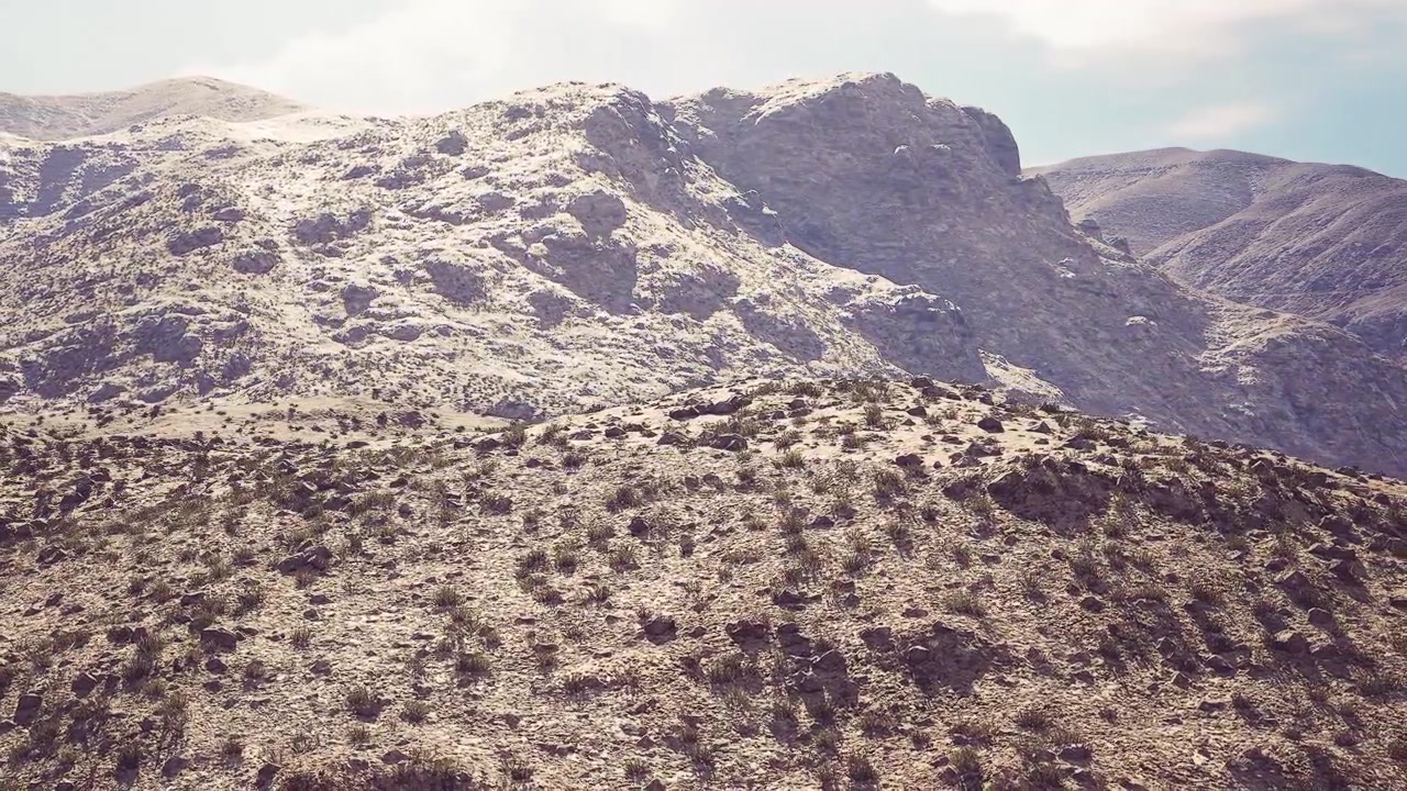 Montagne che si ergono su un terreno roccioso sotto un cielo azzurro e limpido di giorno