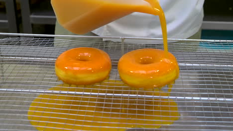 Pouring-mango-sauce-over-donuts