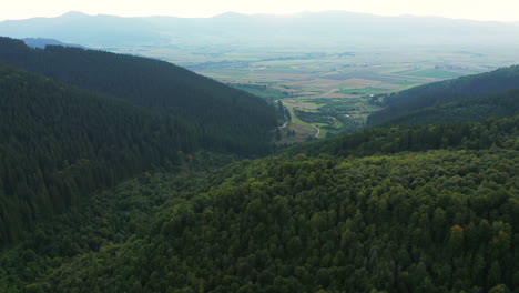 Slow-flyover-above-Nyerges-Teto,-Romania,-looking-down-to-farmland-in-valley