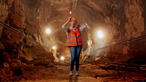full body of asian female engineer with safety helmet screaming goal and dancing celebrating in underground mine tunnel
