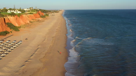 포르투갈의 vale do lobo 해변에 있는 긴 황금빛 모래와 울퉁불퉁한 절벽