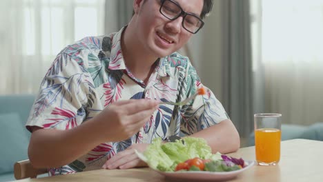 hombre comiendo ensalada en casa