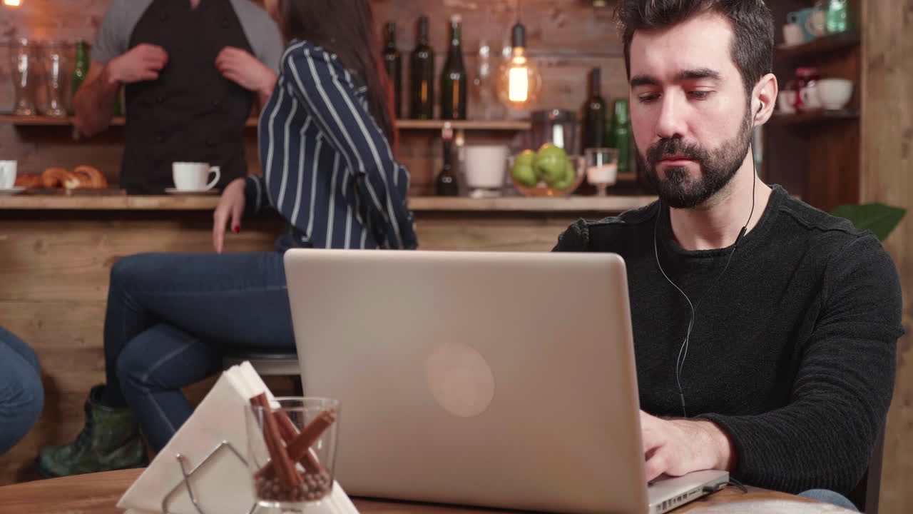 hombre trabajando en una computadora portátil en una cafetería