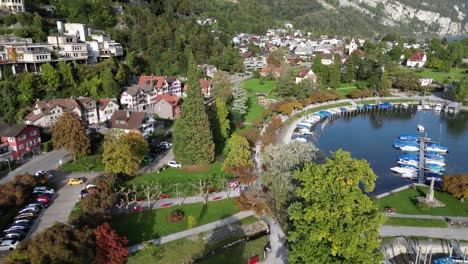 aerial shot of a city in the hilly area situated in the valley with lakes containing motor sports vehicles and a fountain