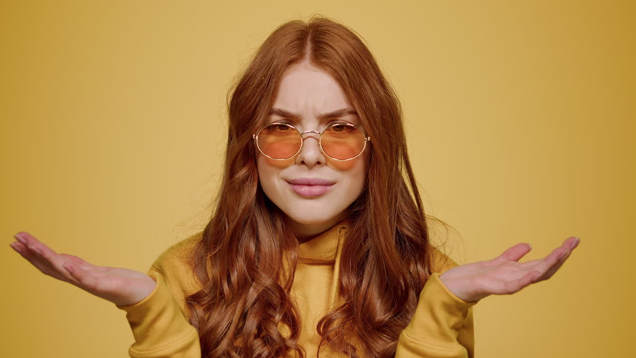 chica molesta haciendo gestos con las manos sobre un fondo naranja. mujer actuando en el estudio