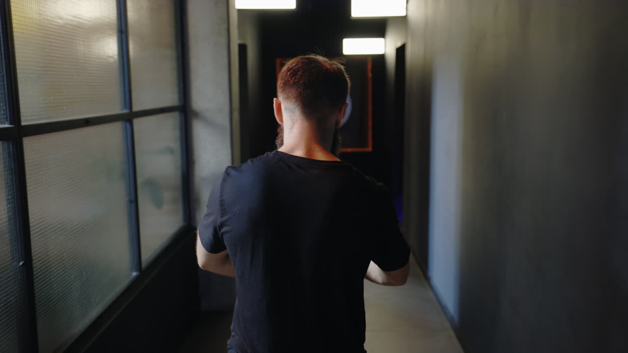 Man Walking Down a Dark Corridor