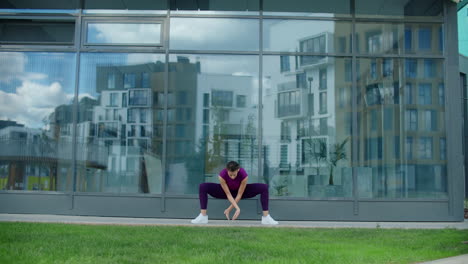 woman doing yoga exercises outside a building