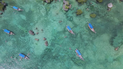 top down view over boats in turquoise water in kwale island coral reef lagoon