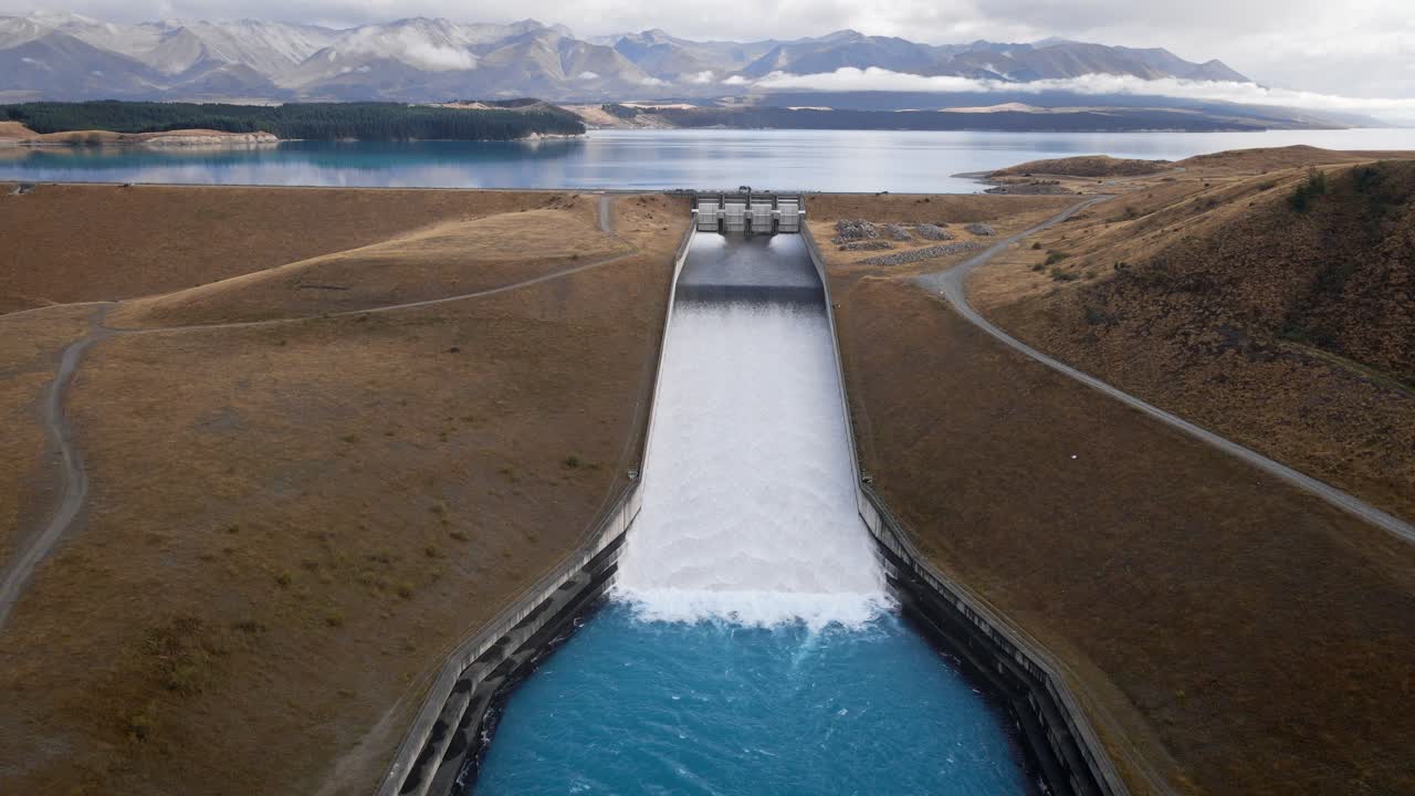 Huge amounts of blue glacier water flowing down ramp at hydroelectricity dam at Lake Pukaki