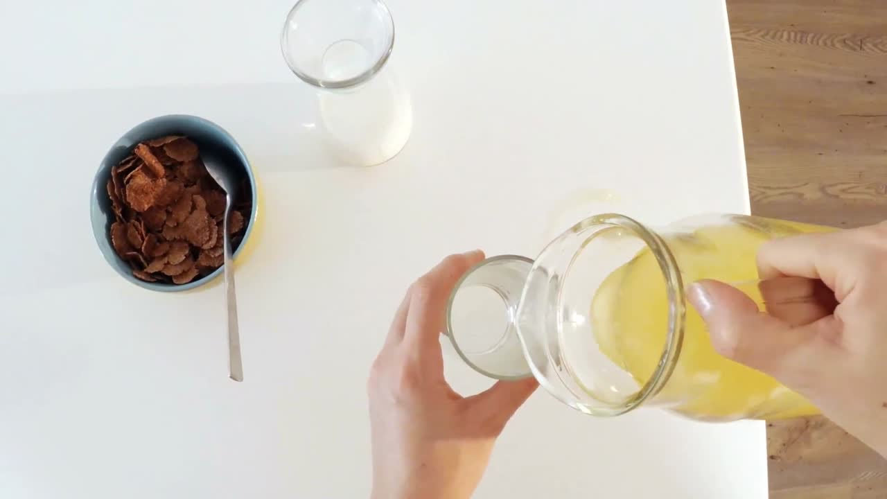 오렌지 주스의 항아리를 유리로  ⁇ 는 여자