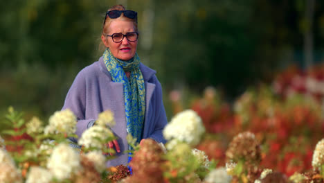 pensioner woman strolling in beautiful floral garden park