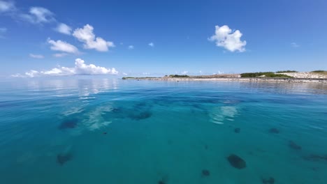 calm turquoise waters with a clear sky, from moving boat perspective