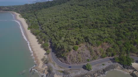 captain cook highway on the coast of borderline beach with lush tropical surroundings in far north queensland, australia