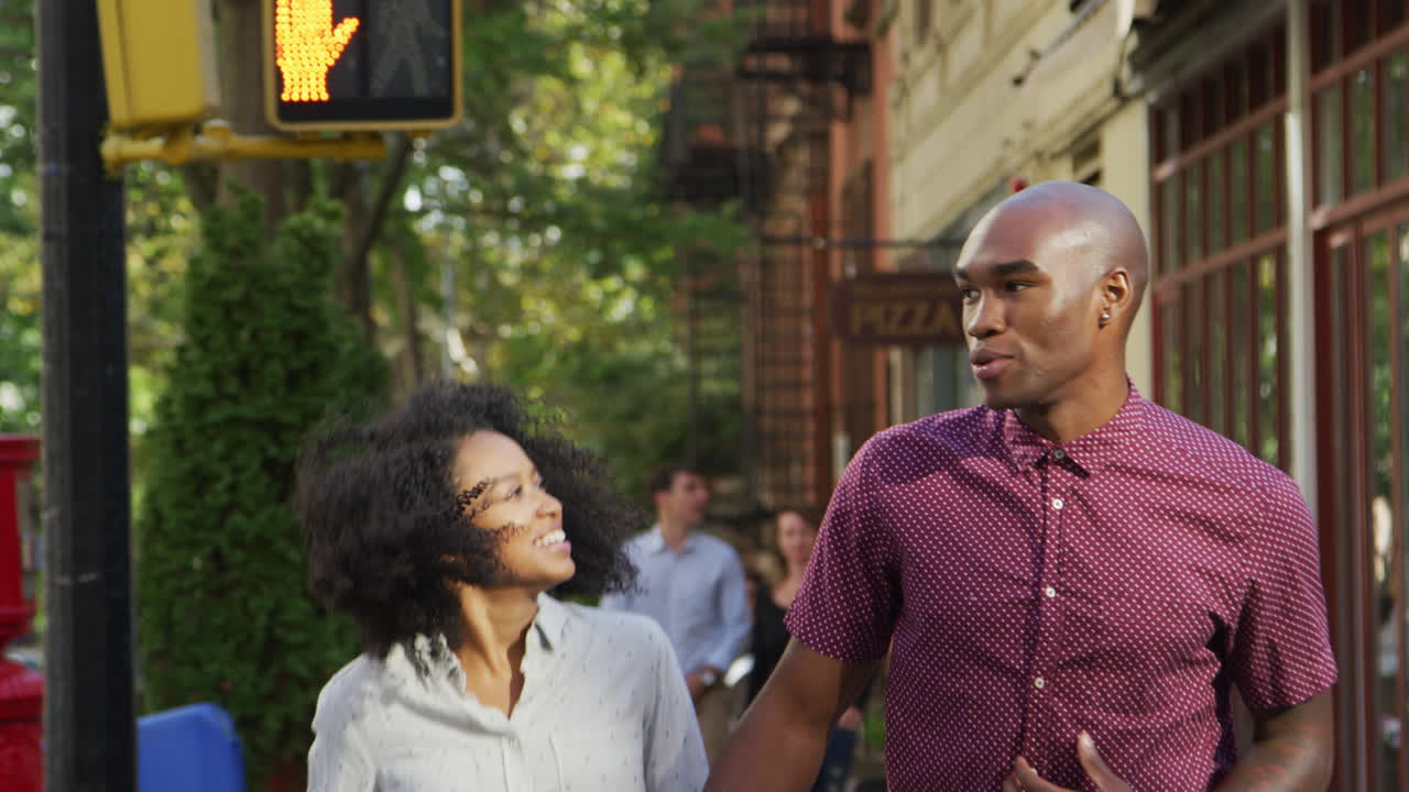 手をつないで通りを歩く夫婦の近くの後ろの景色