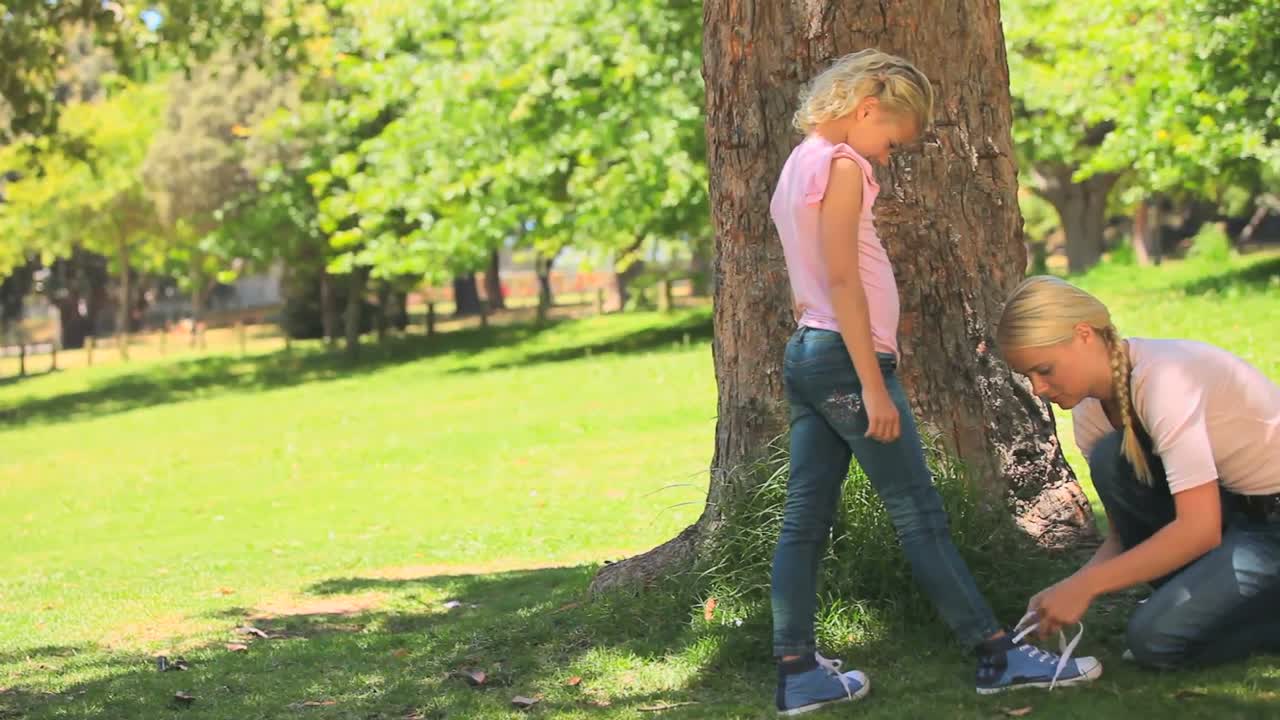 젊은 여성 이 딸 의 신발 을  ⁇ 고 있다