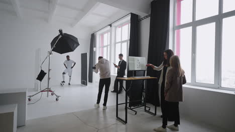 a sporty black male model poses for advertising posters. he plays with the ball for spectacular shots. stylish fashionable sports magazine. a photo shoot made with professional equipment in the studio