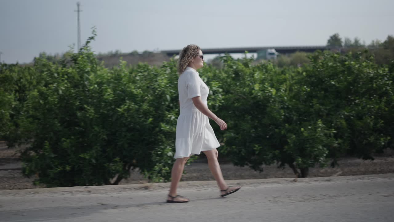 Woman Walking in an Orange Orchard