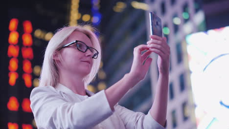 woman tourist takes pictures on times square in new york tourism and travel in the usa