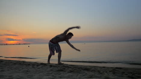 Hombre-Mostrando-Acrobacias-En-La-Playa-Durante-La-Puesta-De-Sol