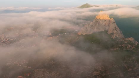 majestic mountain peak shrouded in fog at sunrise