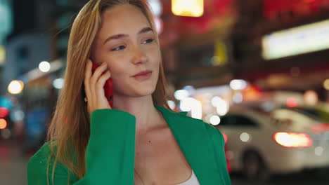 young woman on a phone call in a city at night